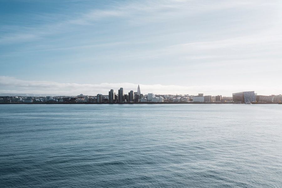 Reykjavik harbor in skyline in distance, view from ocean during summer.