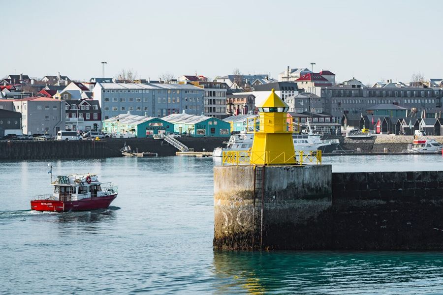 Yellow lighthouse at Reykjavik harbor in summer.
