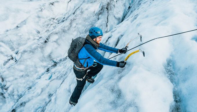 Close up of male using ice picks to ice climb on Vatnajokull.