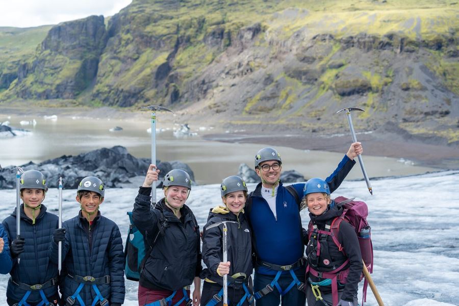 Group of people posing for picture on glacier