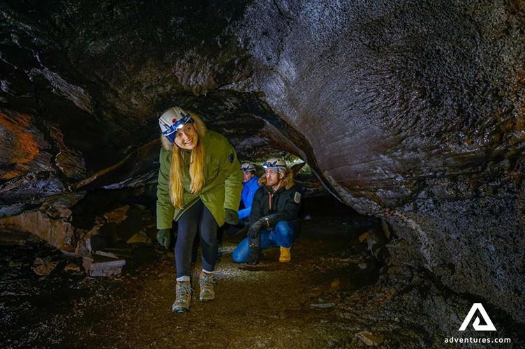 small group happy while exploring lava cave in reykjanes