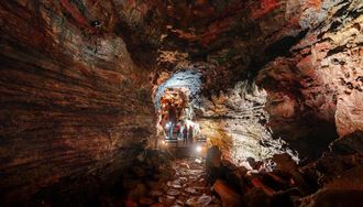 Tourists Inside A Lava Tunnel On An Expedition