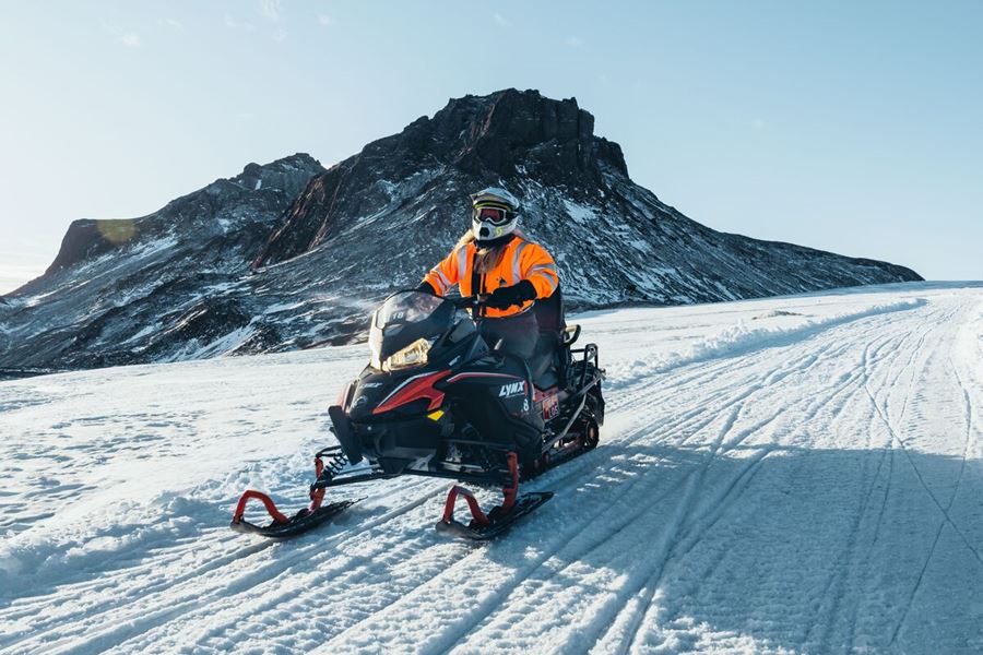 Driver On A Snowbile On Langjokull Glacier In Front Of A Hill