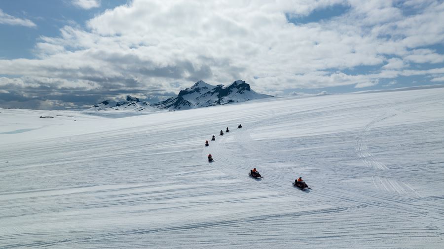 Snowmobiles Driving in Row