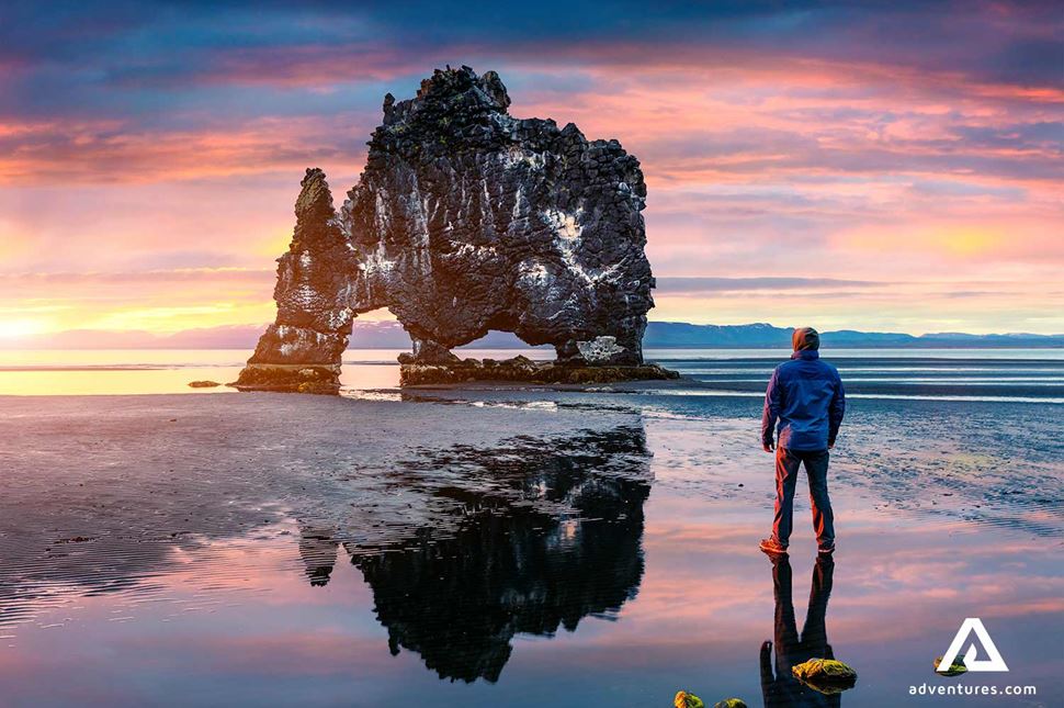 man standing and watching a sunset near hvitserkur