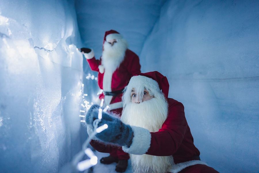 Two Yule Lads Hanging Lights In An Ice Tunnel in iceland