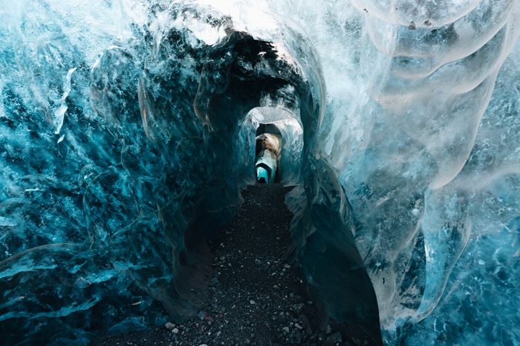 Opening at ice formation with beautiful ice wall texture and black blue and white colors