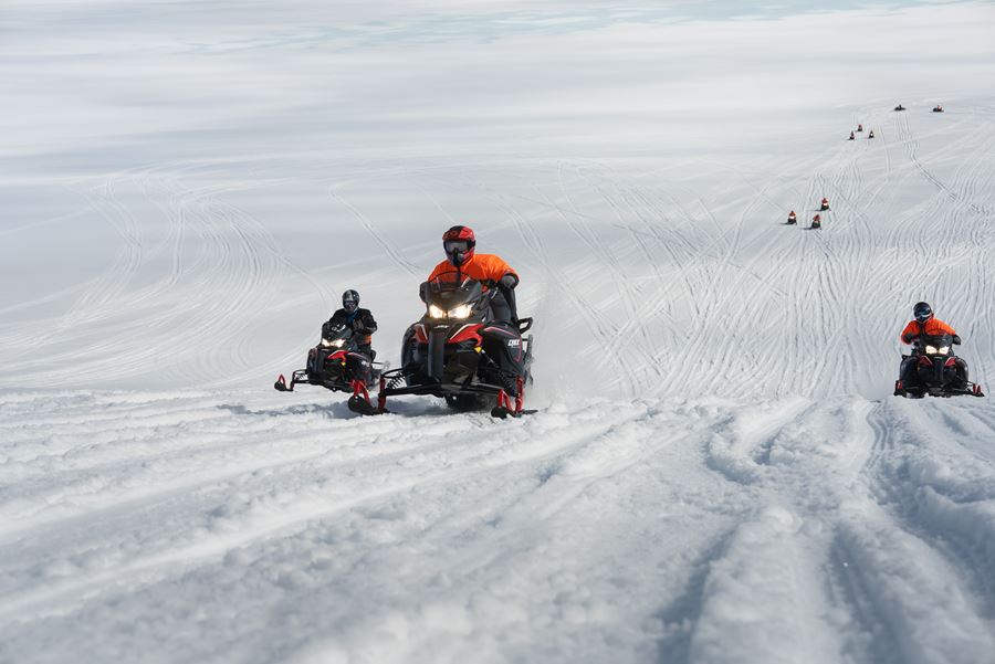 People Riding Snowmobiles