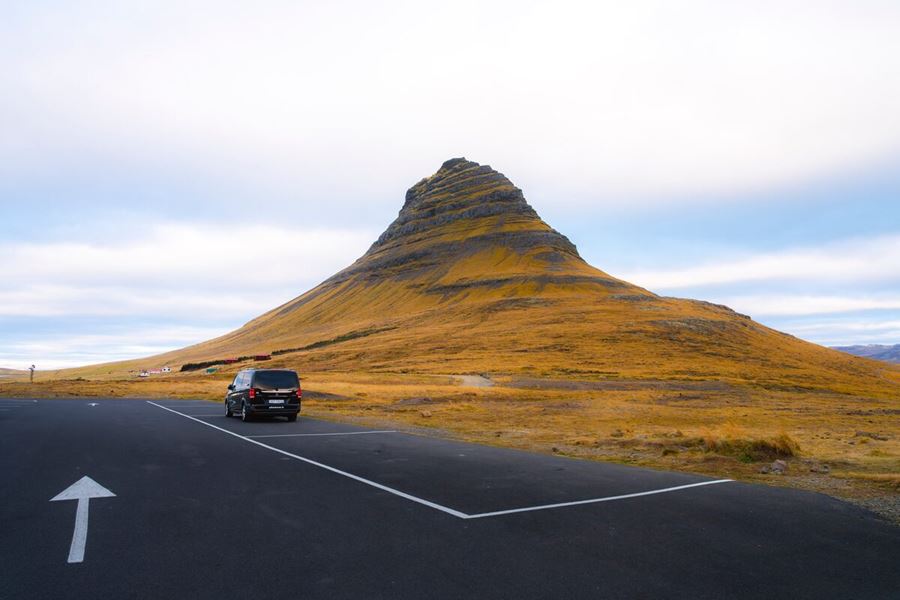 A Car Standing Next To Kirkjufell Mountain