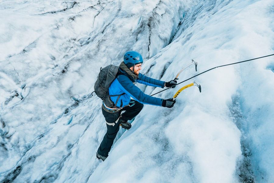 Close up of male using ice picks to ice climb on Vatnajokull.
