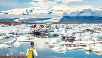 a man walking around the glacier lagoon path