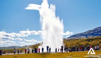 people watching geysir eruption in summer in iceland