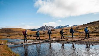 Hikers crossing river in Landmannalaugar in Iceland