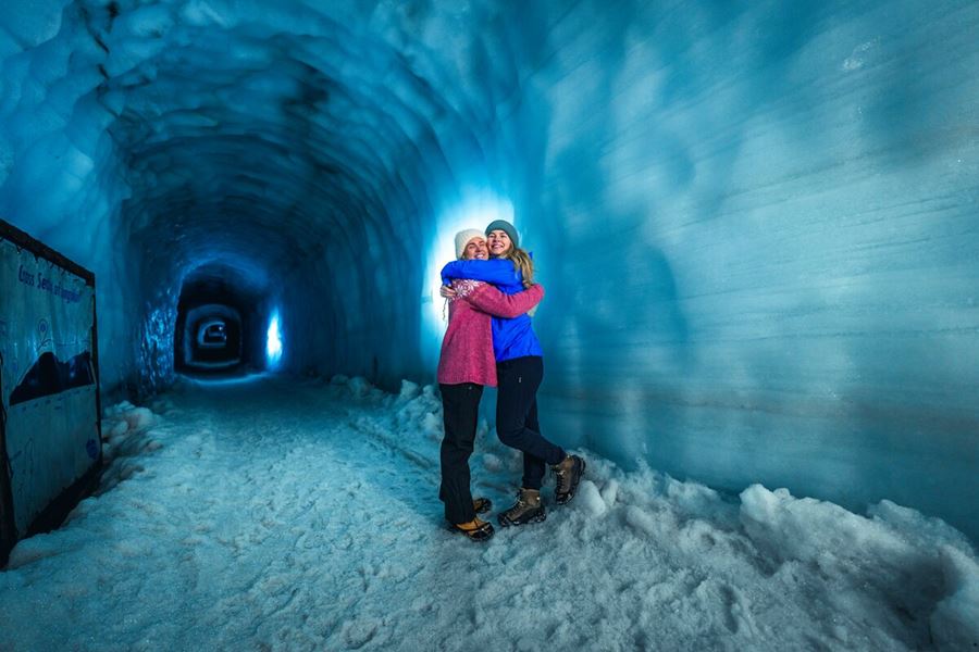 Two friends hugging posing for photo inside Langjokull ice tunnel 