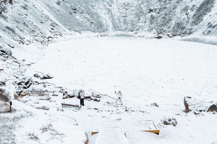 Tourists Taking Pictures Near Snowy Kerid Crater in Iceland