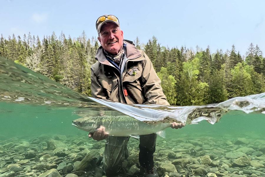 Fisherman holding a fish under clear water