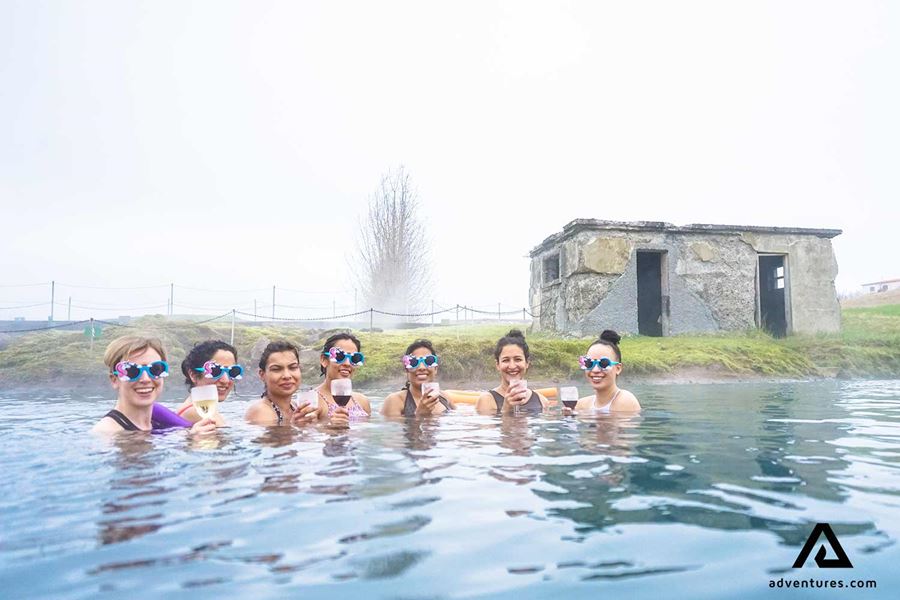 happy women bathing in secret lagoon