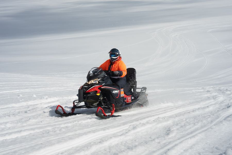 Man Riding Snowmobile On Snow