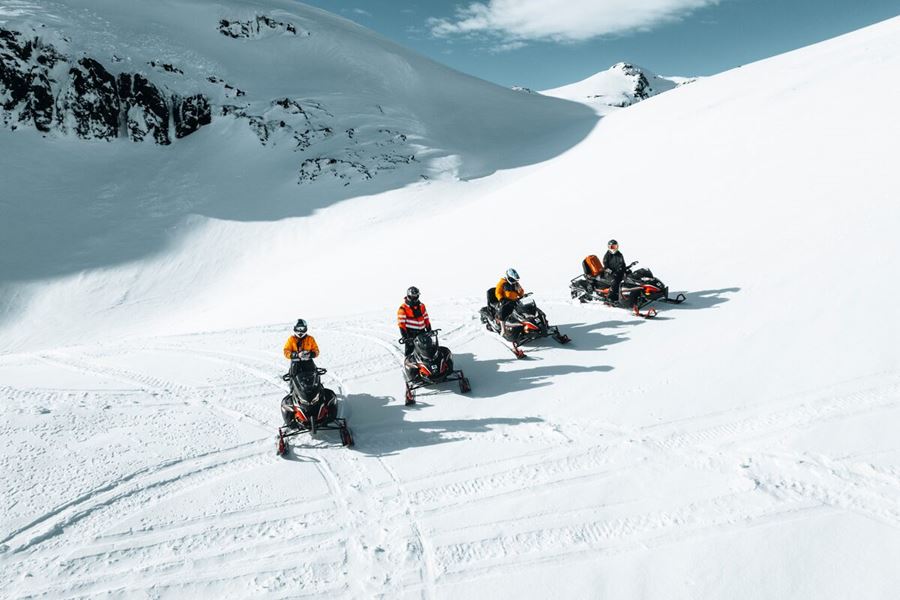 Four Snowmobiles And Their Drivers On Snowy glacier In Iceland