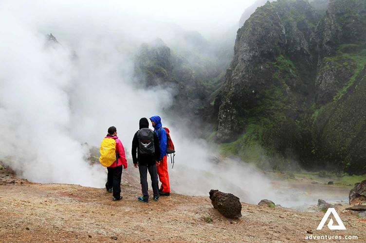 people standing near reykjadalur hot springs
