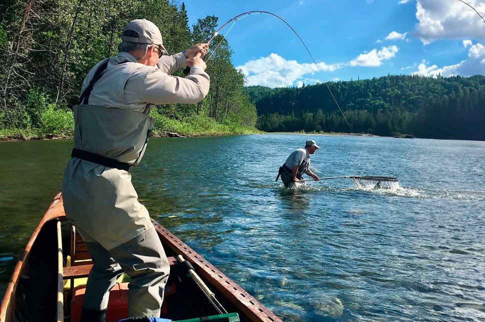 Two men fishing and caching fishes in river