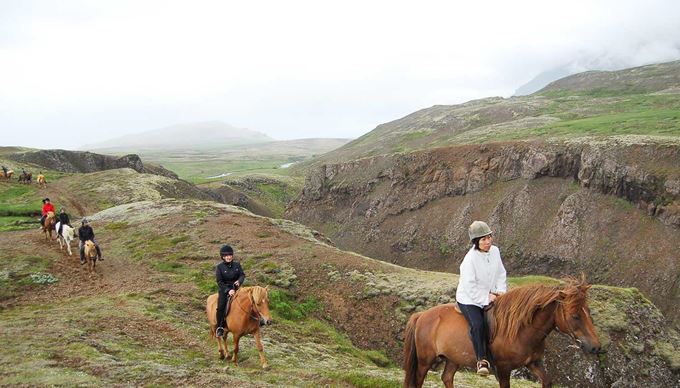 riding horses near a canyon in iceland